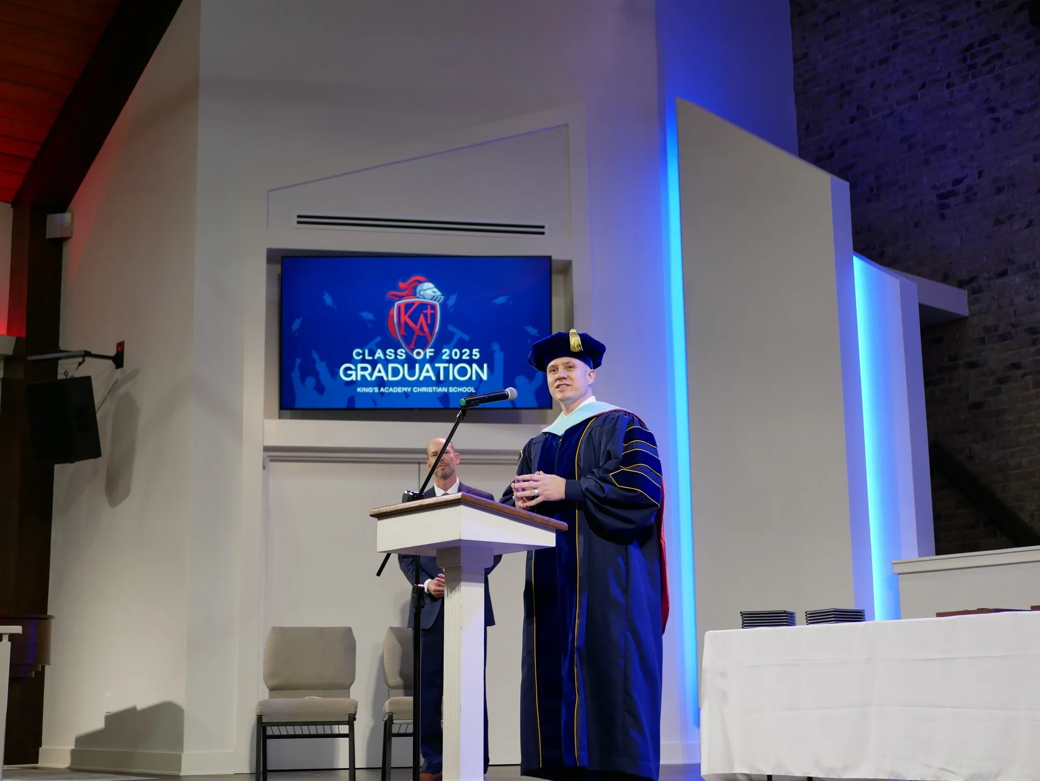 Aaron addressing the King’s Academy class of 2025 graduation in doctoral regalia